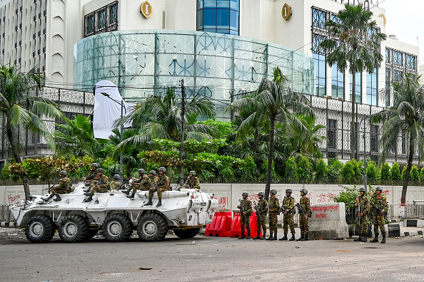 Des soldats bangladais montent la garde lors d'un couvre-feu à la suite d'affrontements entre la police et des militants du Mouvement des étudiants contre la discrimination, à Dhaka, le 5 août 2024. (MUNIR UZ ZAMAN/AFP via Getty Images)