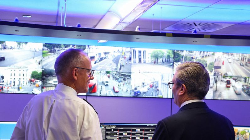 Le Premier ministre britannique Keir Starmer (à dr.) regarde les écrans de vidéosurveillance avec le commissaire de la police métropolitaine Mark Rowley dans la salle d'ingénierie de la salle des opérations spéciales du commandement et du contrôle de la police métropolitaine au siège de la police de Lambeth à Londres, le 9 août 2024. (TOBY MELVILLE/POOL/AFP via Getty Images)