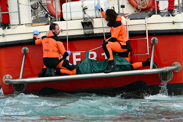 Des plongeurs des Vigili del Fuoco, le corps italien des pompiers, arrivent avec un sac mortuaire à l'arrière du bateau à Porticello près de Palerme, le 21 août 2024, deux jours après le naufrage du yacht de luxe Bayesian battant pavillon britannique. Les plongeurs à la recherche de six personnes disparues après le naufrage d'un superyacht au large de la Sicile lors d'une tempête ont retrouvé deux corps, a indiqué à l'AFP une source proche des recherches. Le Bayesian, qui comptait 22 personnes à bord dont 10 membres d'équipage, était ancré à quelque 700 mètres du port avant l'aube lorsqu'il a été frappé par une trombe marine, sorte de mini tornade. (Photo  ALBERTO PIZZOLI/AFP via Getty Images)

