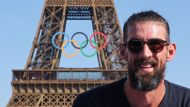 L'ancien nageur et médaillé d'or américain Michael Phelps pose sur la scène du Champions Park au Trocadéro lors des Jeux olympiques de Paris 2024 à Paris le 6 août 2024, avec la Tour Eiffel et les anneaux olympiques visibles en arrière-plan. (JACK GUEZ/AFP via Getty Images)