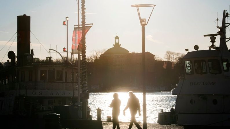 Des gens se promènent par un temps froid mais ensoleillé sur les quais de Standvagen à Stockholm, en Suède, le 20 novembre 2020. (FREDRIK SANDBERG/TT News Agency/AFP via Getty Images)