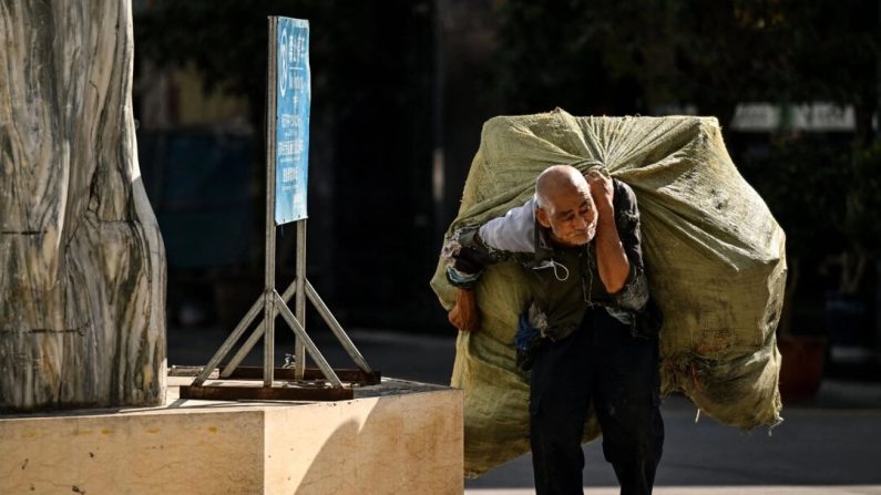 Un homme âgé porte sur son dos un sac d’objets recyclables à Ruili, dans la province chinoise du Yunnan, le 13 janvier 2023. (Noel Celis/AFP via Getty Images)