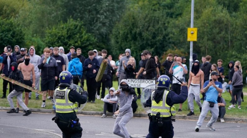 Un jeune lance un poteau de clôture en direction de la police lors d'une manifestation anti-immigration près du Holiday Inn Express à Rotherham, en Angleterre, le 4 août 2024. (Danny Lawson/PA Wire)