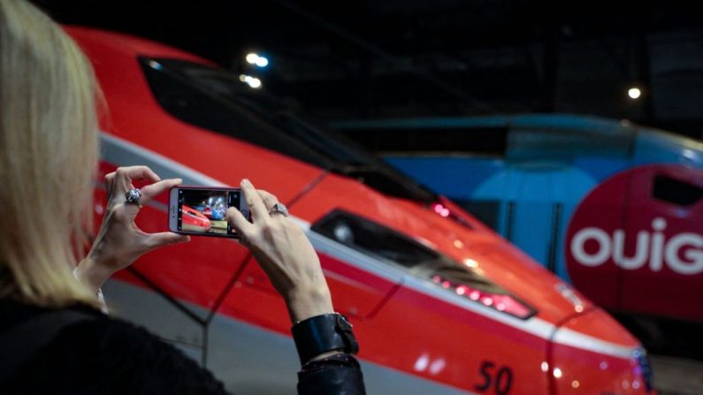 Une voyageuse prend en photo le Frecciarossa, un train à grande vitesse de l'opérateur national italien Trenitalia, le 18 décembre 2021. (GEOFFROY VAN DER HASSELT/AFP via Getty Images)