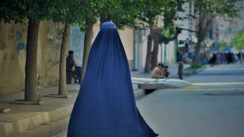 Une femme vêtue d'une burqa marche dans une rue de Kaboul. Les talibans ont imposé aux femmes afghanes de se couvrir entièrement en public, idéalement avec la burqa traditionnelle et de ne plus parler en public. (AHMAD SAHEL ARMAN/AFP via Getty Images)