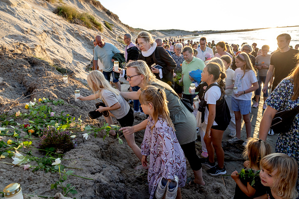 Des fleurs et des bougies sont déposées en mémoire des deux garçons allemands morts ensevelis en jouant sur la plage de Noerre Vorupoer, au Danemark le 28 août 2024. (Photo LARS PAULI/Ritzau Scanpix/AFP via Getty Images)