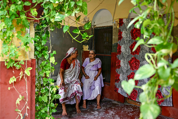 Sur cette photo prise le 23 août 2024, la résidente Gulab Bai (à droite) s'entretient avec son amie et co-résidente dans l'enceinte de Kashi Vaas du Mumukshu Bhawan, un hospice pour les personnes en quête de salut à Varanasi.  (Photo by NIHARIKA KULKARNI/AFP via Getty Images