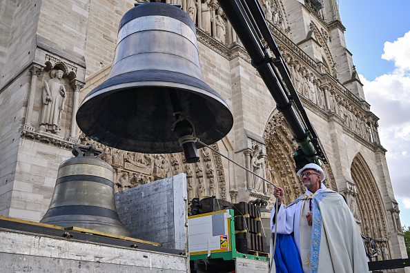 Le recteur de la cathédrale Notre-Dame, Olivier Ribadeau Dumas, bénit l'une des huit cloches du beffroi nord de la cathédrale Notre-Dame de Paris, le 12 septembre 2024. (ED JONES/AFP via Getty Images)