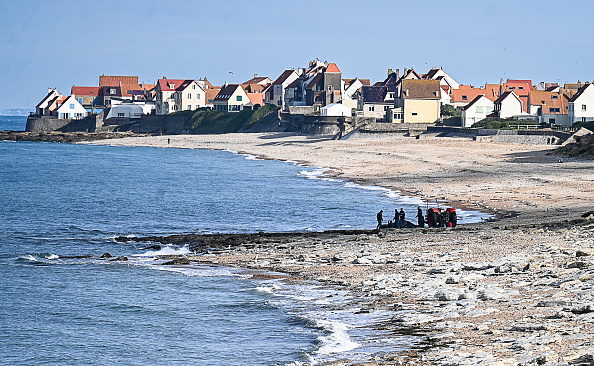 Des gendarmes utilisent un tracteur pour tirer l’embarcation de migrants endommagée après tenté de traverser la Manche, près d’Ambleteuse (Pas-de-Calais) le 15 septembre 2024. (Photo BERNARD BARRON/AFP via Getty Images)