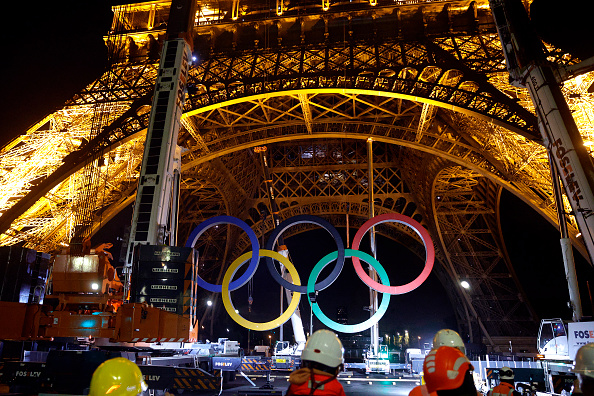 Des grues enlèvent les anneaux olympiques de la Tour Eiffel à Paris, le 27 septembre 2024. (GEOFFROY VAN DER HASSELT/AFP via Getty Images)