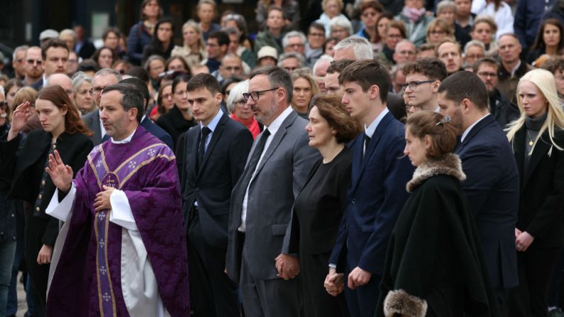 Un prêtre s'approche des proches de Philippine, avant la cérémonie funéraire devant la cathédrale de Versailles, près de Paris, le 27 septembre 2024. (ALAIN JOCARD/AFP via Getty Images)