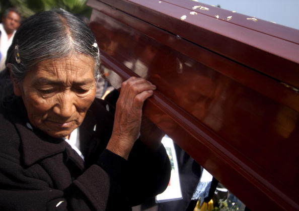 Les cercueils des victimes du massacre de « La Cantuta » en 1992 sont transportés à l'université de La Cantuta à Lima, le 18 juillet 2008. Les dépouilles de neuf étudiants et d'un professeur, assassinés en 1992 par l'escadron de la mort « Colima » sous le gouvernement du président Albetro Fujimori (1990-2000), étaient restées dans une fosse commune jusqu'à présent.  (Photo ERNESTO BENAVIDES/AFP via Getty Images)