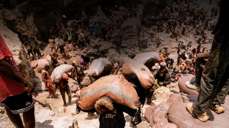 Des mineurs artisanaux transportent des sacs de minerai à la mine artisanale de Shabara près de Kolwezi, en République démocratique du Congo, le 12 octobre 2022. (Junior Kannah/AFP via Getty Images)