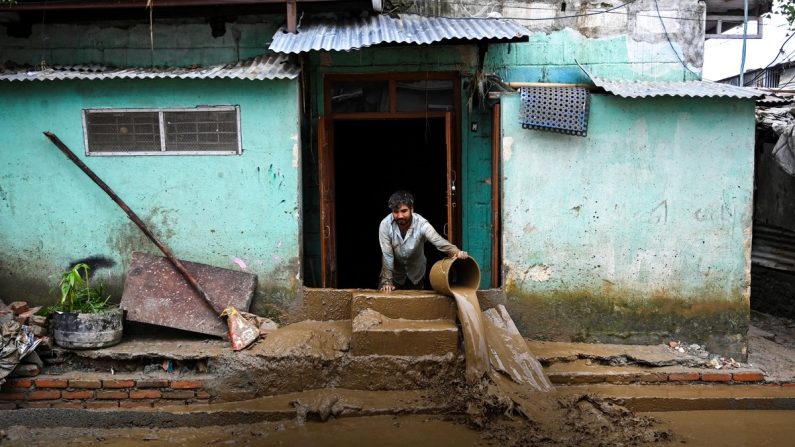 Un homme nettoie la boue de sa maison dans une zone touchée par les inondations suite aux fortes pluies de mousson à Katmandou, au Népal, le 29 septembre 2024. (Prakash Mathema/AFP via Getty Images)