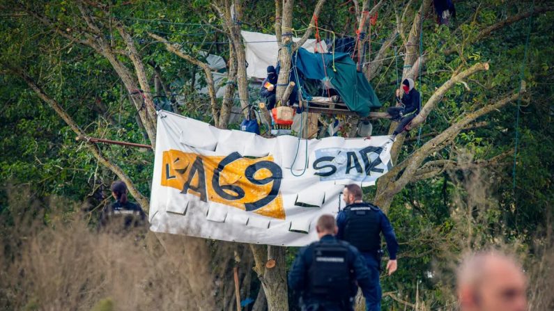 Des opposants à l'autoroute A69, qui se font appeler « écureuils », sont perchés sur un arbre à l'occasion d'une opération de la gendarmerie française menée pour libérer le site de la ZAD (Zone à défendre) de Le Verger, à Verfeil, en France, le 23 septembre 2024. (Idriss Bigou-Gilles/AFP via Getty Images)