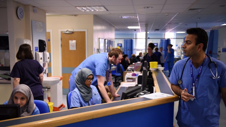 Des membres du personnel clinique travaillent sur des ordinateurs dans le service des accidents et des urgences du "Royal Albert Edward Infirmary" à Wigan, dans le nord-ouest de l'Angleterre. (OLI SCARFF/AFP via Getty Images)