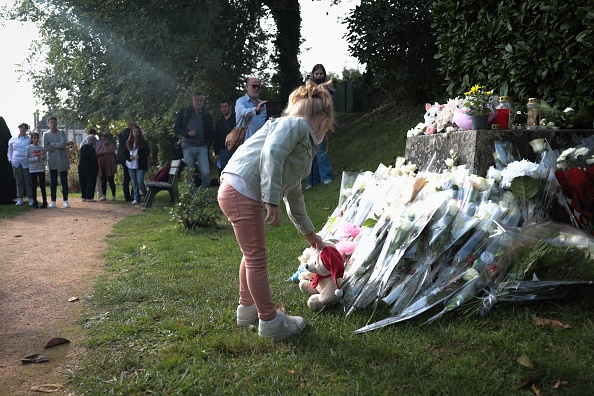 Un enfant dépose un ours en peluche lors d'un hommage à Lisa, 3 ans, devant la mairie de Conches-en-Ouches, le 30 septembre 2023. (Photo LOU BENOIST/AFP via Getty Images)