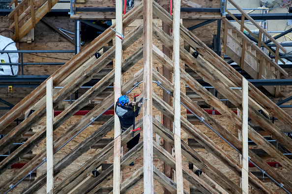 Un charpentier travaille sur le toit de la cathédrale Notre-Dame de Paris pendant les travaux de reconstruction, sur l'île de la Cité à Paris, le 8 décembre 2023. Cette flèche est reconstruite à l'identique de l'originale, détruite lors de l'incendie du 15 avril 2019.. (Photo CHRISTOPHE ENA/POOL/AFP via Getty Images)
