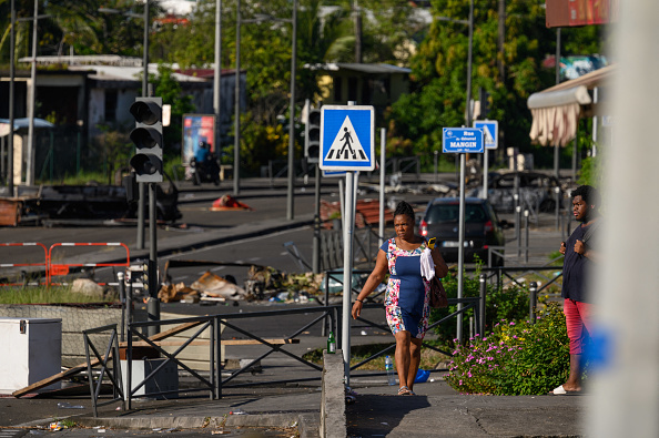 Un piéton marche entre des débris suite aux récentes manifestations sur le coût de la vie, à Fort-de-France, en Martinique, le 23 septembre 2024. (ED JONES/AFP via Getty Images)