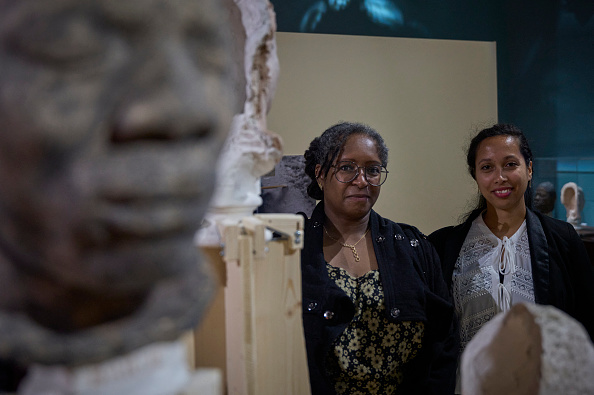 Doris Lily (C) et Clarisse Lily, descendantes d'un captif africain, posent lors de l'exposition « Visages d'ancêtres » au château de Blois, dans le centre de la France. Depuis 1940, le château royal de Blois abrite dans ses réserves une collection de 53 bustes moulés à partir d'anciens captifs africains, dont la plupart ont été réduits en esclavage à l'île Maurice. Cette collection a été rassemblée sur l'île en 1846 par Eugène de Froberville dans le cadre de son « enquête ethnologique » sur l'Afrique de l'Est. (Photo GUILLAUME SOUVANT/AFP via Getty Images)
