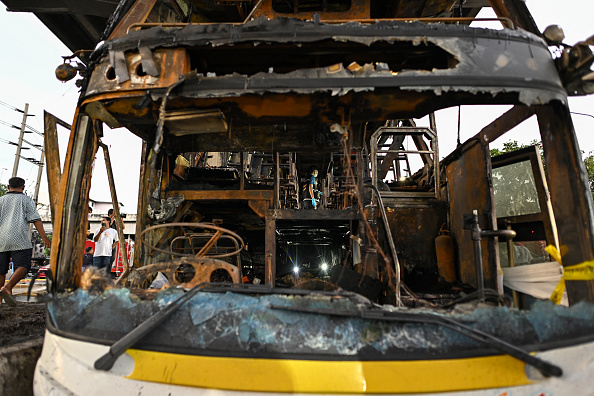 Un bus incendié transportait des élèves et des enseignants dans la banlieue de Bangkok le 1er octobre 2024. (MANAN VATSYAYANA/AFP via Getty Images)