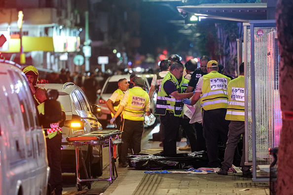 Des volontaires de l'équipe d'intervention d'urgence israélienne Zaka nettoient la scène après l'attentat à une station de tram au sud de Tel-Aviv, le 1er octobre 2024. (Photo JACK GUEZ/AFP via Getty Images)