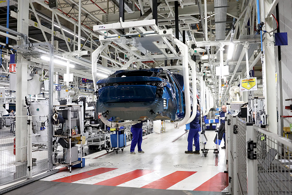 Des employés travaillent sur la ligne de production de la nouvelle voiture électrique Peugeot e-3008 et e-5008 à l'usine Stellantis à Sochaux. (FREDERICK FLORIN/AFP via Getty Images)