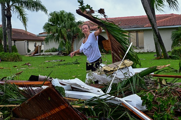 Illustration. Une femme ramasse les débris causés par l’ouragan Milton, en Floride, le 10 octobre 2024.   (GIORGIO VIERA/AFP via Getty Images)