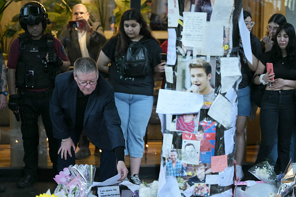 Geoff Payne (à g.), le père du chanteur des One Direction Liam Payne, regarde une note placée là où les fans ont rendu hommage à son fils défunt devant l'hôtel CasaSur à Buenos Aires le 18 octobre 2024. (JUAN MABROMATA/AFP via Getty Images)