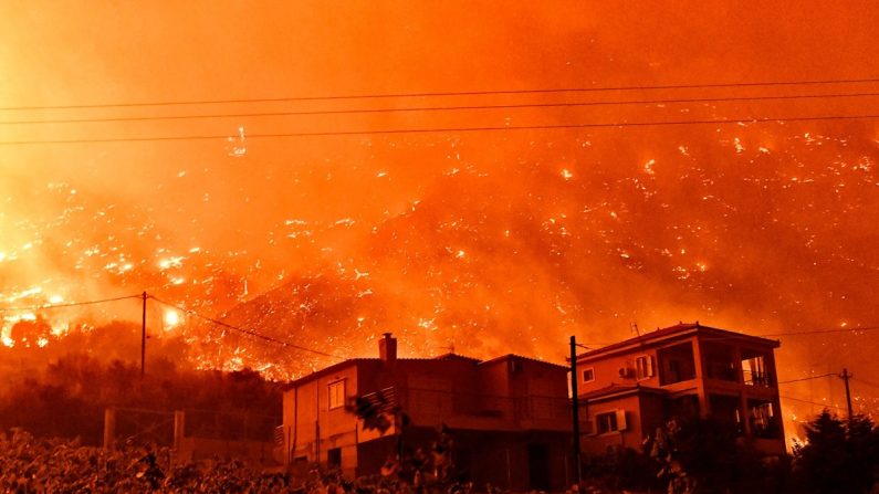 Un incendie de forêt s'approche des maisons du village d'And Loutro, au sud d'Athènes, en Grèce, le 30 septembre 2024. Au moins deux personnes ont été retrouvées mortes et sept villages ont été évacués du fait de l'incendie. (Valerie Gache/AFP via Getty Images)