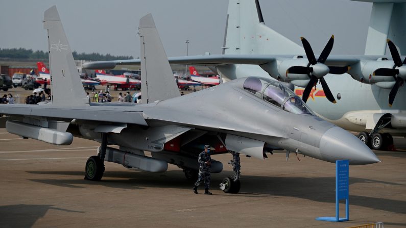 Un militaire passe devant l'avion de combat multirôle J-16 de Shenyang Aircraft Corporation pour la Force aérienne de l'Armée populaire de libération (PLAAF) lors de la 13e Exposition internationale de l'aviation et de l'aérospatiale de Chine à Zhuhai, dans la province du Guangdong (sud de la Chine), le 28 septembre 2021. (NOEL CELIS/AFP via Getty Images)