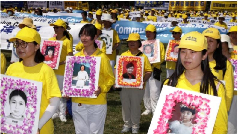 Des pratiquants de Falun Gong et des sympathisants tiennent des photos de victimes persécutées par le régime chinois lors d'une manifestation et d'un rassemblement annuels sur le National Mall à Washington, le 16 juillet 2021. (Alex Wong/Getty Images)