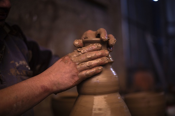 L'artisan palestinien Sid Atallah façonne un pot sur un tour de potier dans l'atelier familial à Deir al-Balah, dans le centre de la bande de Gaza, le 11 février 2021. (Photo SAID KHATIB/AFP via Getty Images)