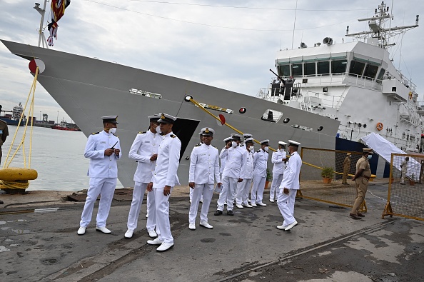 Des officiers de la Garde côtière se tiennent à côté du patrouilleur offshore « VIGRAHA » de la Garde côtière indienne lors de sa cérémonie de mise en service à Chennai le 28 août 2021. (Photo ARUN SANKAR/AFP via Getty Images)