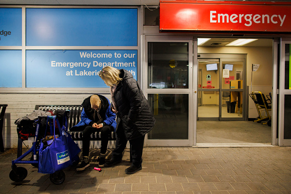 Image d'illustration : une assistante sociale parle avec un sans-abri devant l'hôpital d'Oshawa en Ontario (Canada). (Photo by COLE BURSTON/AFP via Getty Images)