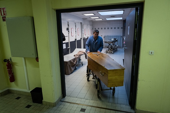 Un croque-mort sort un cercueil de la chambre froide d'un centre funéraire à Mulhouse, le 18 octobre 2024. (SEBASTIEN BOZON/AFP via Getty Images)