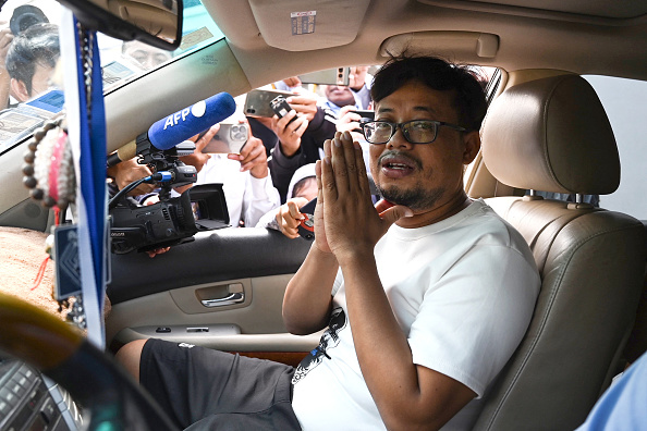 Le journaliste cambodgien Mech Dara fait des gestes aux représentants des médias alors qu'il est assis dans une voiture après sa libération de la prison provinciale de Kandal, près de Phnom Penh, le 24 octobre 2024. (Photo TANG CHHIN SOTHY/AFP via Getty Images).