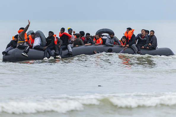 Des migrants se pressent sur le canot pneumatique d'un passeur pour tenter de traverser la Manche, après avoir quitté la plage de l'Ecault à Saint-Étienne-au-Mont, près de Neufchâtel-Hardelot. (SAMEER AL-DOUMY/AFP via Getty Images)