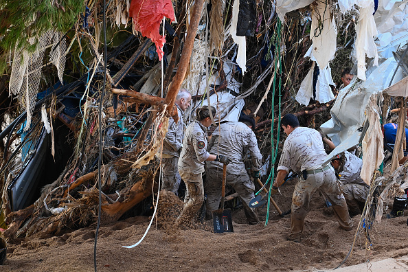 Des membres de l'armée espagnole fouillent dans les débris alors qu'ils recherchent des victimes le long d'une rivière, le 2 novembre 2024, à la suite des inondations dévastatrices dans la région de Valence, à l'est de l'Espagne.   (JOSE JORDAN/AFP via Getty Images)