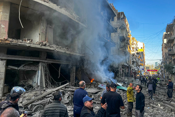 Des personnes se rassemblent sur le site d'une frappe aérienne israélienne dans le quartier de Ghobeiry, à Beyrouth, le 15 novembre 2024. (IBRAHIM AMRO/AFP via Getty Images)