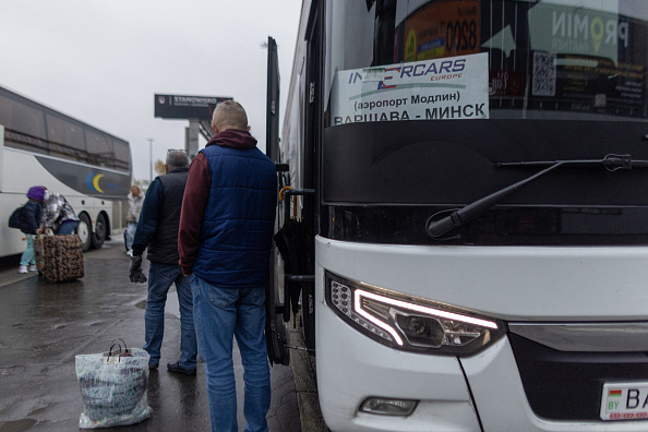 Un chauffeur se tient à côté de l'entrée du bus à destination de Minsk, en Biélorussie, à la gare routière de Varsovie Ouest, le 30 octobre 2024. (WOJTEK RADWANSKI/AFP via Getty Images)