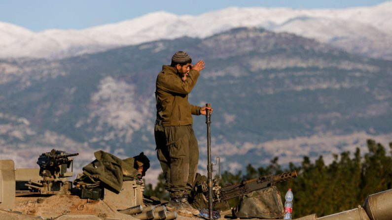 Un soldat israélien se tient au-dessus d'un char stationné près de la frontière avec le Liban dans la région de la haute Galilée, dans le nord d'Israël, le 26 novembre 2024. (JALAA MAREY/AFP via Getty Images)