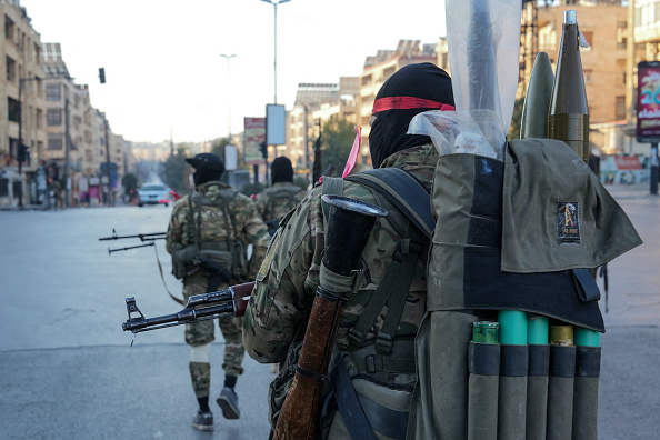 Des combattants anti-gouvernementaux patrouillent dans le centre d'Alep le 30 novembre 2024. (MUHAMMAD HAJ KADOUR/AFP via Getty Images)