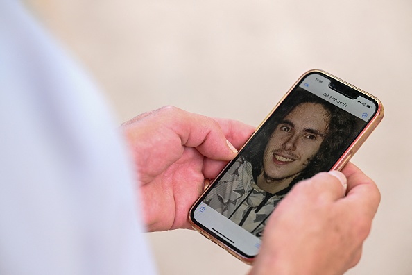 Paul Raoult, 63 ans, le père de Sébastien Raoult, montre un téléphone avec un portrait de son fils à Épinal, le 1er août 2022. (JEAN-CHRISTOPHE VERHAEGEN/AFP via Getty Images)