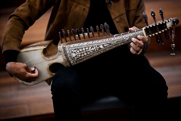 Ramiz, 19 ans, étudiant en musique à l'Institut national de musique d'Afghanistan (Anim), joue d'un instrument afghan appelé rubab, au Conservatoire de musique de Braga, au nord du Portugal, le 5 mars 2021. Un an et demi après avoir fui l'Afghanistan, les 58 jeunes musiciens de l'Institut national de musique d'Afghanistan commencent une nouvelle vie à Braga, dans le nord du Portugal. Pour eux, la survie de leur musique et de l'héritage culturel afghan est une priorité. (PATRICIA DE MELO MOREIRA/AFP via Getty Images)