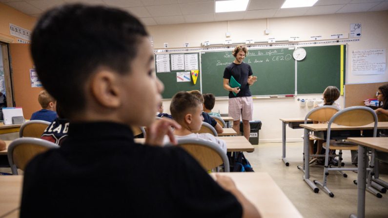 Des écoliers sont accueillis par leur professeur en entrant dans leur classe le premier jour de la nouvelle année scolaire à l'école primaire Bonnevaine Zenatti à Marseille, dans le sud-est de la France, le 2 septembre 2024. (CLEMENT MAHOUDEAU/AFP via Getty Images)