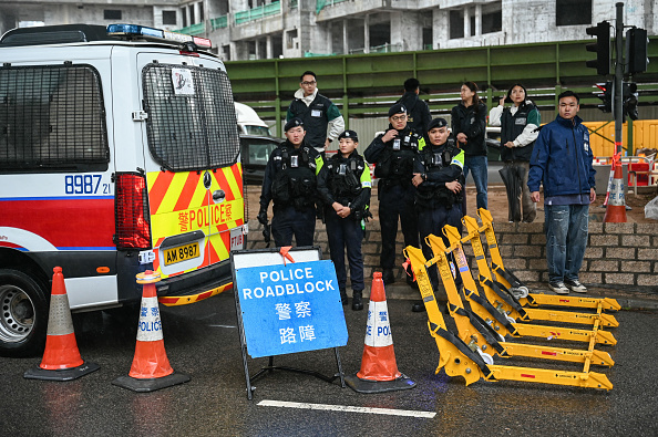 La police tient un barrage routier devant le tribunal de première instance de West Kowloon, à Hong Kong, le 20 novembre 2024. (PETER PARKS/AFP via Getty Images)