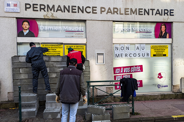 Des agriculteurs murent le bureau des députés du parti LFI Damien Maudet et Manon Meunier à Limoges, le 6 décembre 2024. (FRANCK LAGIER/AFP via Getty Images)