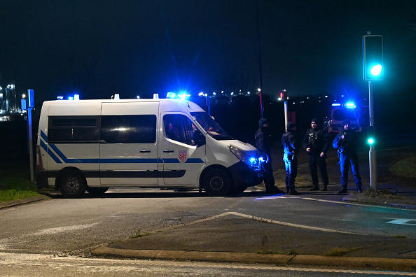 Des CRS bloquent une route près d'un camp de migrants où deux agents de sécurité et deux migrants ont été abattus, près de Dunkerque le 14 décembre 2024. (Photo BERNARD BARRON/AFP via Getty Images)