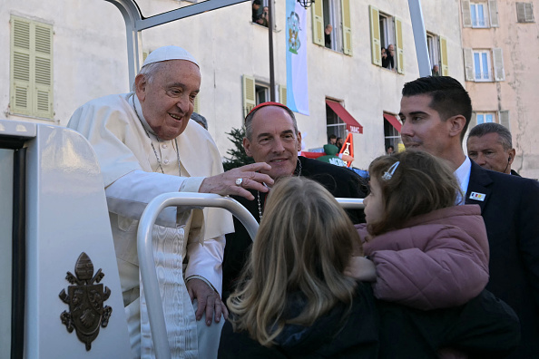 Le pape François bénit une enfant alors qu'il arrive pour rendre hommage à la petite statue de la Madonuccia (la sainte patronne d'Ajaccio) à Ajaccio en Corse, le 15 décembre 2024. (Photo BERTRAND GUAY/AFP via Getty Images)